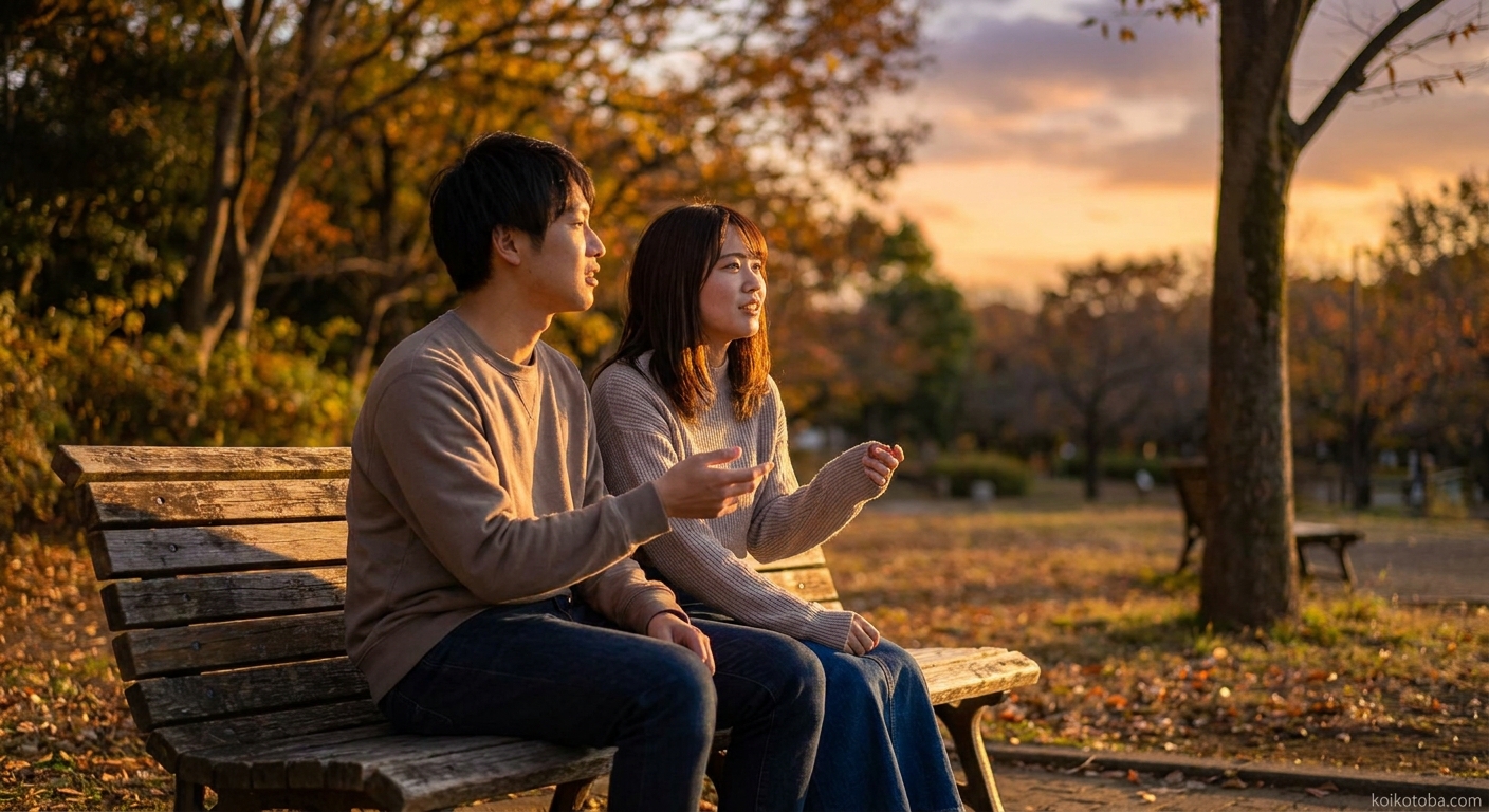 夕暮れの公園ベンチで話す若い男女