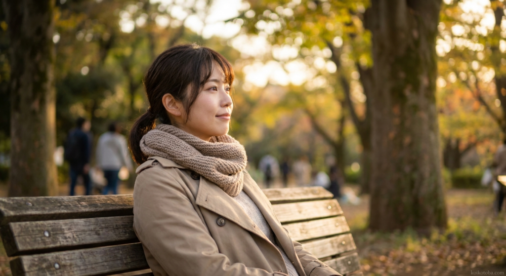 夕暮れの公園のベンチに一人静かに座る女性
