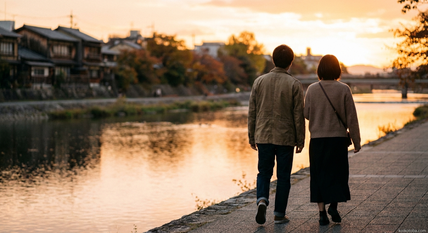 夕暮れの川沿いを並んで歩く二人の後ろ姿